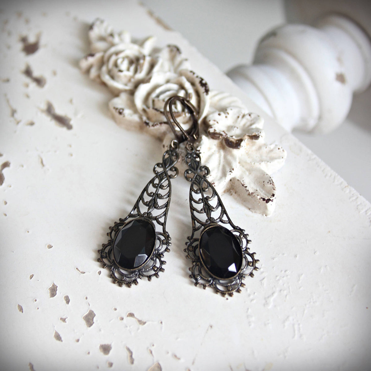 Antique-style silver filigree earrings with faceted black gemstone drops.